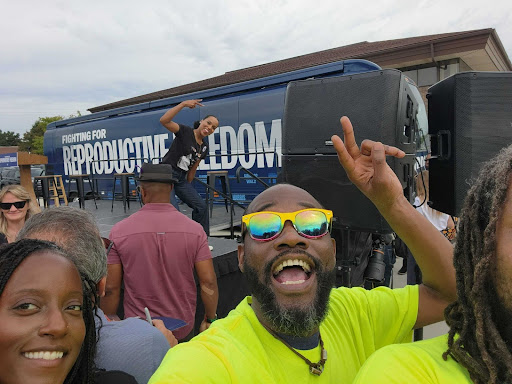 canvassers holding up peace signs in front of bus where kerry washington is holding up peace sign